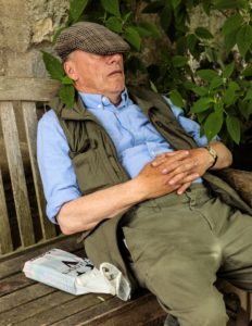 A man snoozing on a bench at the Oxford Botanic Garden & Arboretum
